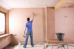 A,Wide,Shot,Of,A,Man,Plastering,Wall,In,An